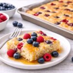 Présentation finale d'une portion de crêpe-dans-une-tôle avec des petits fruits et du sirop