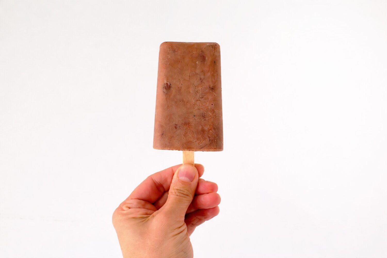 une main tient un popsicle de style fudge double chocolat-wooloo