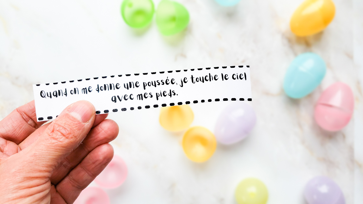 main qui tient un énigme pour la chasse aux cocos de pâques extérieur du blogue wooloo