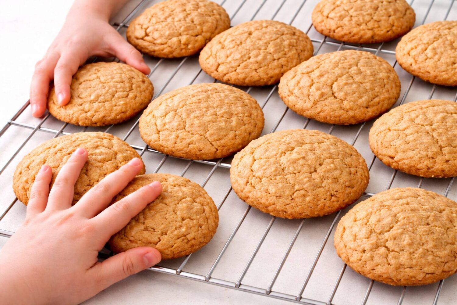 Biscuits à l’avoine et à l’érable qui sortent du four avec des mains d'enfants