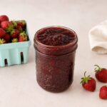 Pot de confiture au fraises maison avec un panier de fraises fraîches